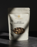 Packaging of Nut Basket roasted pistachios on a dark background