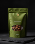 Green package of Nut Basket raw almonds on a dark background
