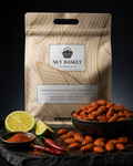 Nut Basket packaging with roasted nuts, limes, and chilies on a dark surface